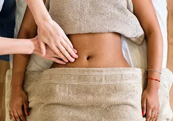 Aplicação de técnica de massagem na região abdominal